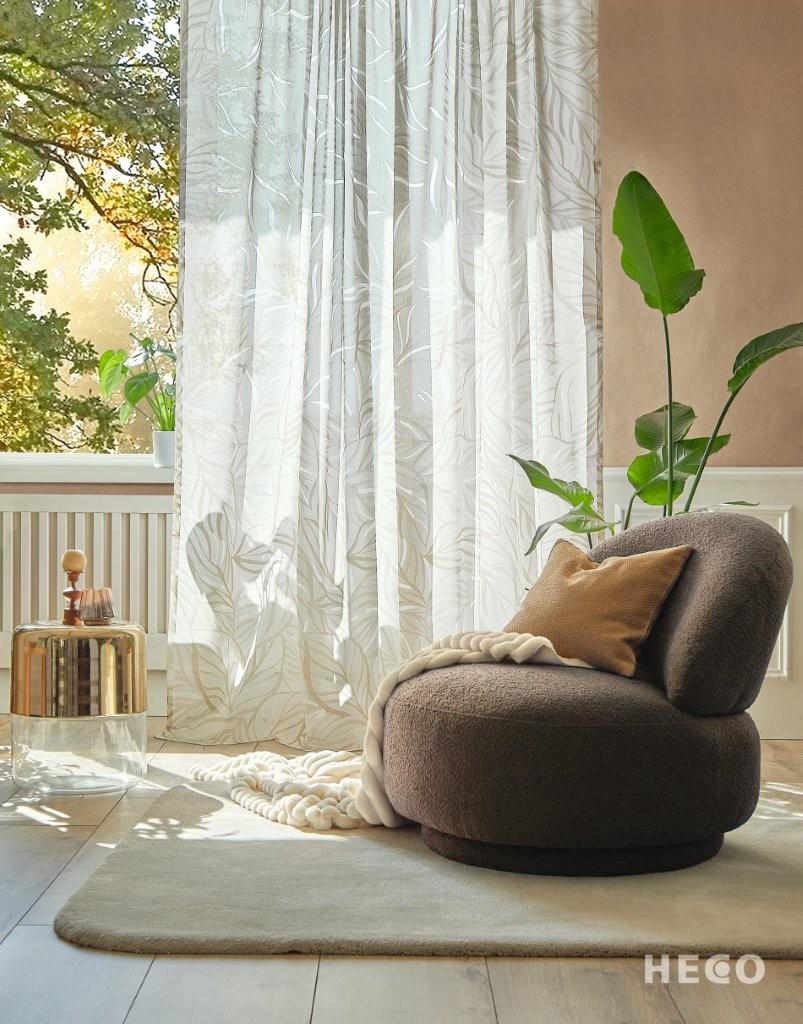 Gemütliche Leseecke mit rundem Polstersessel, Vorhang, Decke und Zimmerpflanzen